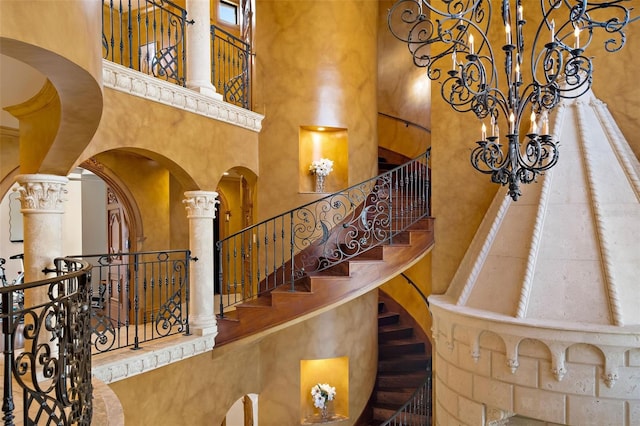 stairs featuring arched walkways, decorative columns, and a towering ceiling