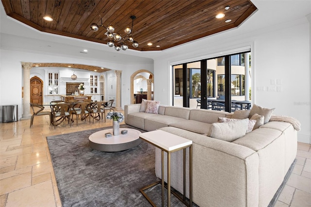 living room featuring arched walkways, recessed lighting, a raised ceiling, stone tile flooring, and wood ceiling