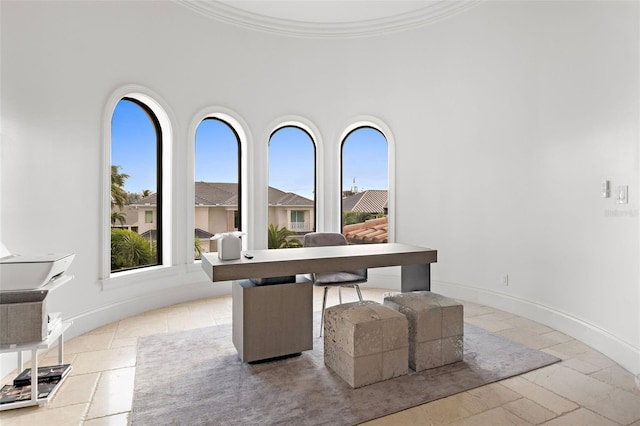 office featuring a healthy amount of sunlight, crown molding, and baseboards