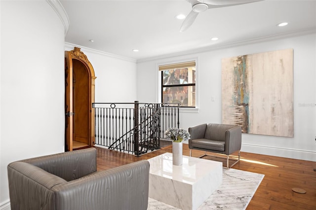 sitting room with recessed lighting, wood finished floors, an upstairs landing, and crown molding