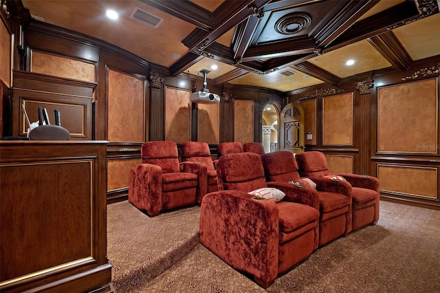 carpeted cinema featuring a decorative wall, coffered ceiling, visible vents, beam ceiling, and crown molding