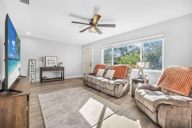 living room with light hardwood / wood-style floors and ceiling fan