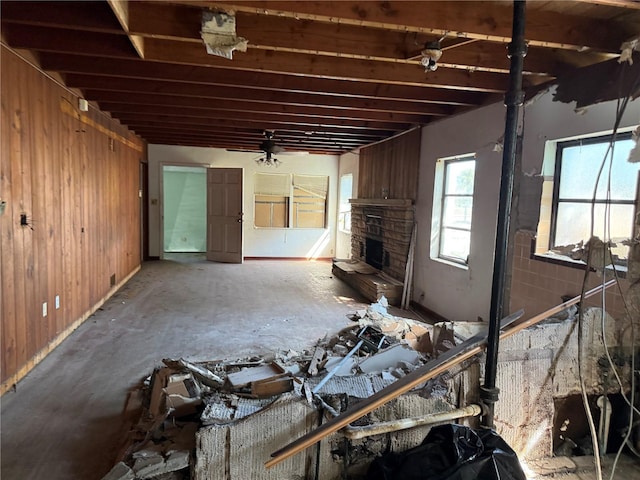 unfurnished living room featuring wood walls and ceiling fan