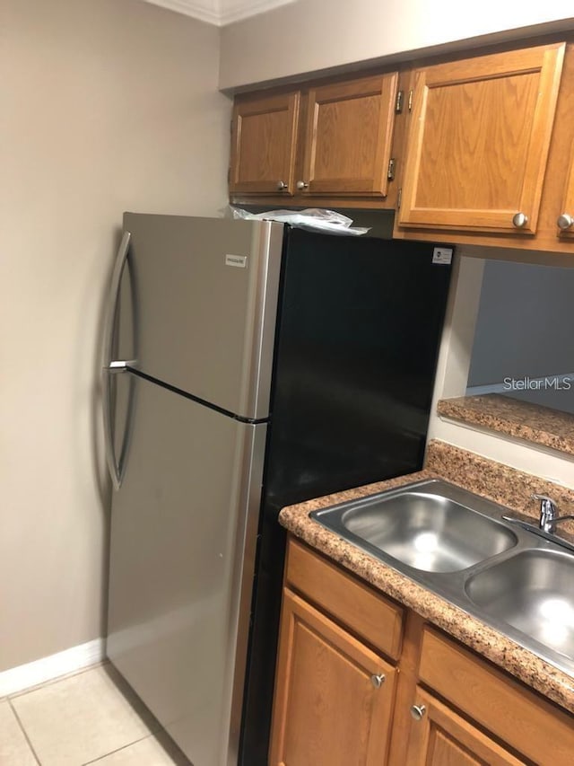 kitchen with sink, light tile patterned floors, and ornamental molding