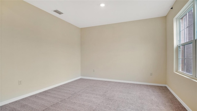 carpeted spare room featuring a healthy amount of sunlight