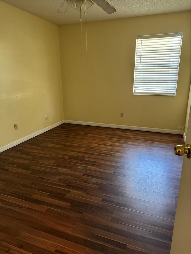 spare room featuring ceiling fan, dark wood-type flooring, and a textured ceiling