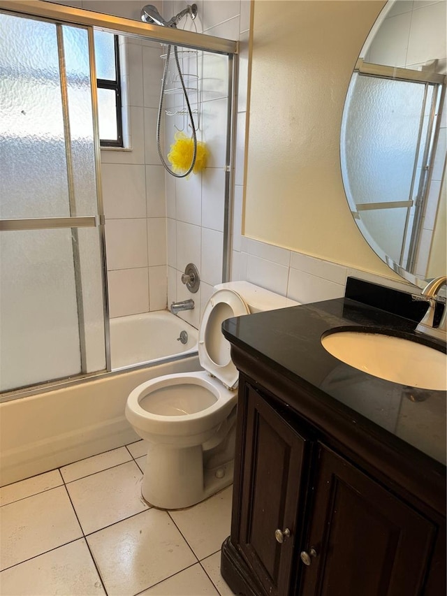 full bathroom with tile patterned floors, shower / bath combination with glass door, vanity, and toilet