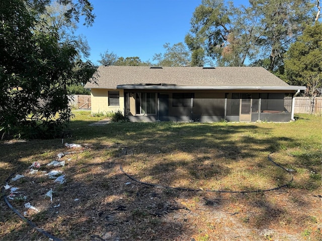 back of property featuring a lawn and a sunroom