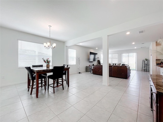 dining room with light tile patterned flooring and an inviting chandelier