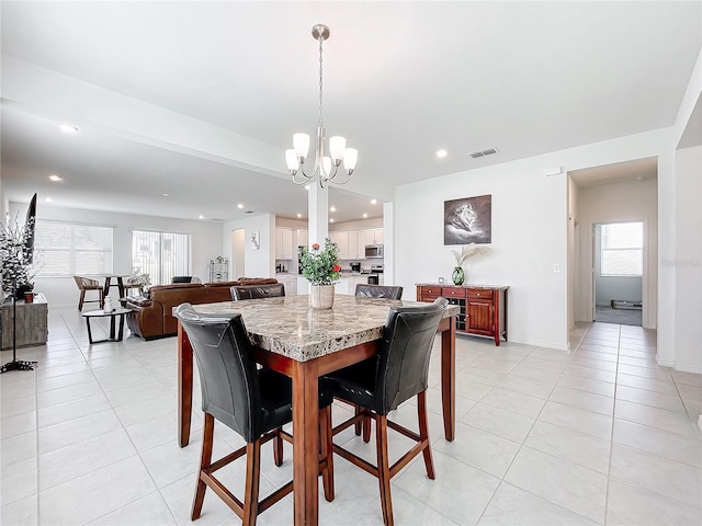 tiled dining area featuring a notable chandelier