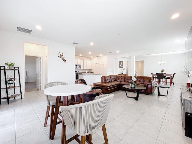 living room with a notable chandelier, light tile patterned floors, and sink