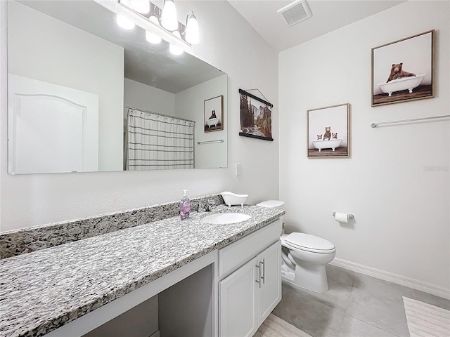 bathroom featuring tile patterned floors, vanity, and toilet