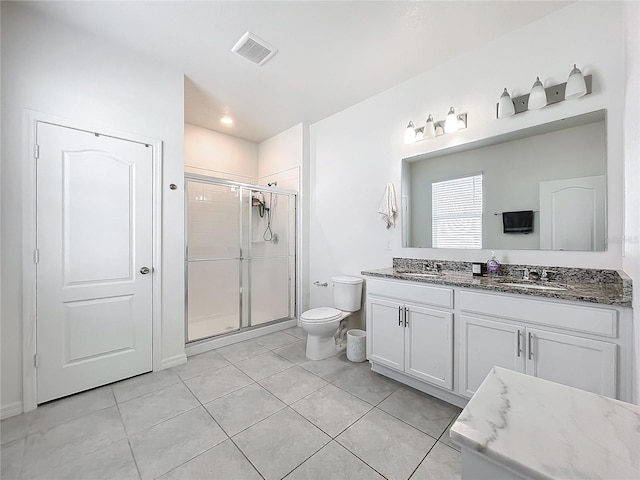 bathroom featuring tile patterned floors, a shower with door, vanity, and toilet