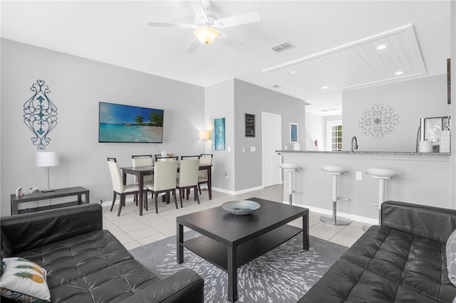 living room with ceiling fan, light tile patterned floors, and sink