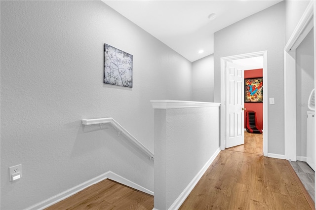 hallway featuring light hardwood / wood-style flooring and vaulted ceiling