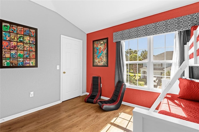 sitting room with hardwood / wood-style floors and vaulted ceiling