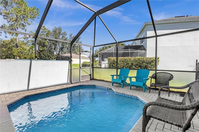 view of swimming pool with a patio area and a lanai