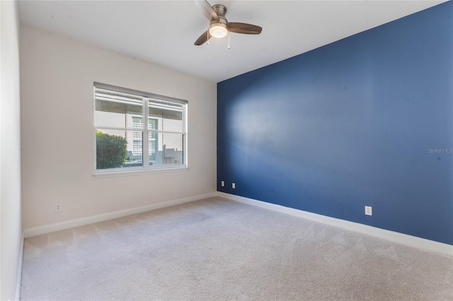 empty room with ceiling fan and light carpet