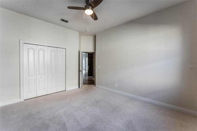 unfurnished bedroom featuring light colored carpet, ceiling fan, and a closet