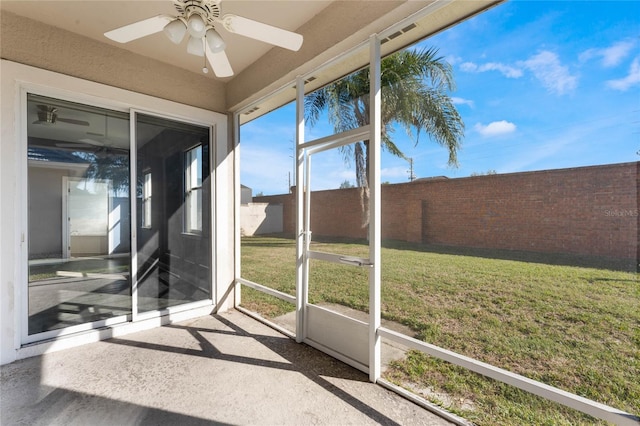 unfurnished sunroom with ceiling fan