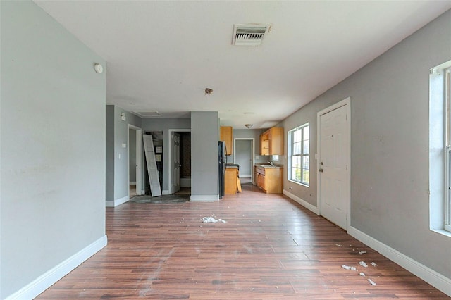 unfurnished living room with sink and wood-type flooring