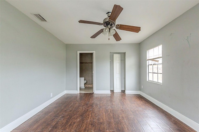 unfurnished bedroom with ensuite bathroom, ceiling fan, and dark hardwood / wood-style floors