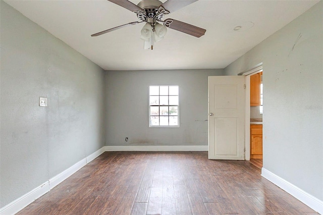 unfurnished room with ceiling fan and dark hardwood / wood-style flooring