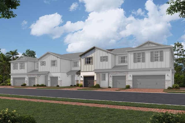 view of front facade featuring board and batten siding, stone siding, decorative driveway, and an attached garage