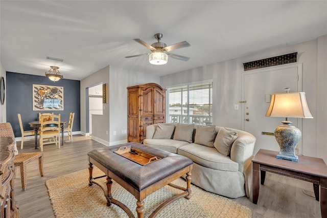 living room featuring ceiling fan and light hardwood / wood-style flooring