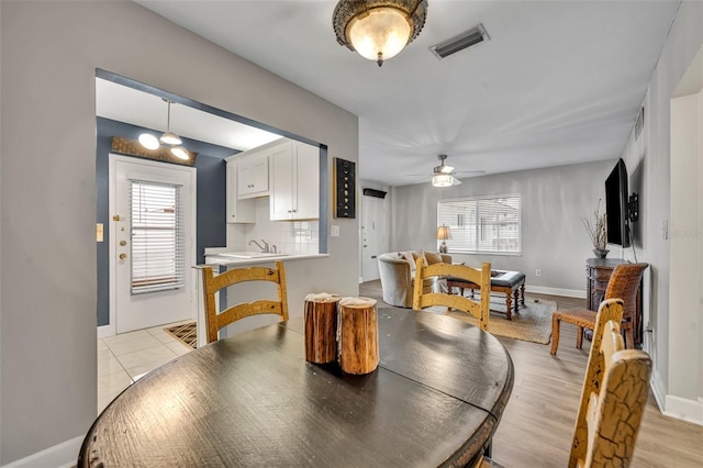 tiled dining space featuring ceiling fan