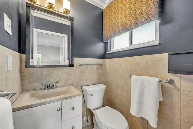 bathroom with vanity, tile walls, and a healthy amount of sunlight