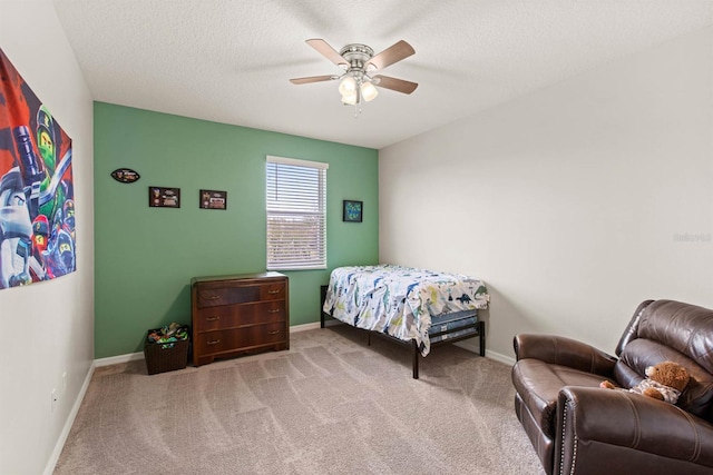 carpeted bedroom featuring ceiling fan and a textured ceiling