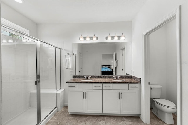 bathroom with tile patterned floors, toilet, a shower with door, and vanity