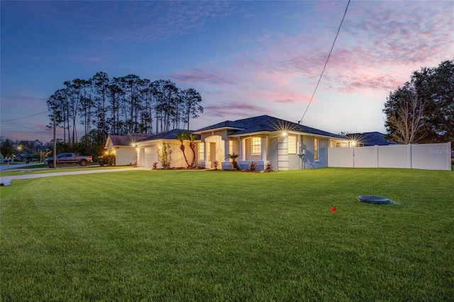 view of front facade featuring a garage and a yard