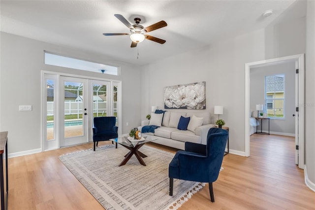 living room with ceiling fan, french doors, and light wood-type flooring