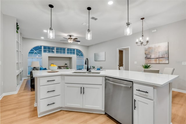 kitchen with ceiling fan with notable chandelier, dishwasher, white cabinetry, sink, and a center island with sink