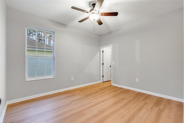 empty room featuring ceiling fan, a textured ceiling, and light hardwood / wood-style flooring