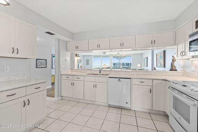 kitchen with white cabinets, white appliances, and sink