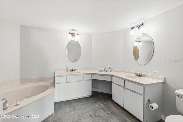 bathroom featuring tile patterned floors, vanity, toilet, and a bathtub