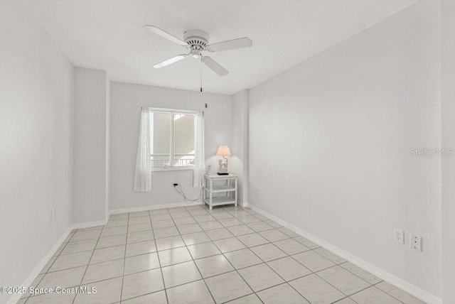 spare room with light tile patterned floors, a textured ceiling, and ceiling fan