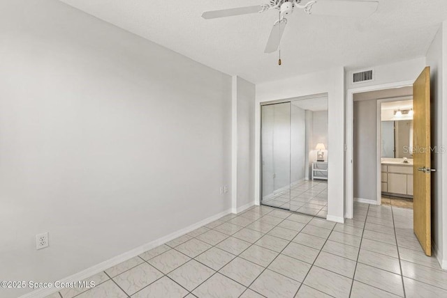 unfurnished bedroom featuring ceiling fan, light tile patterned floors, sink, and a closet