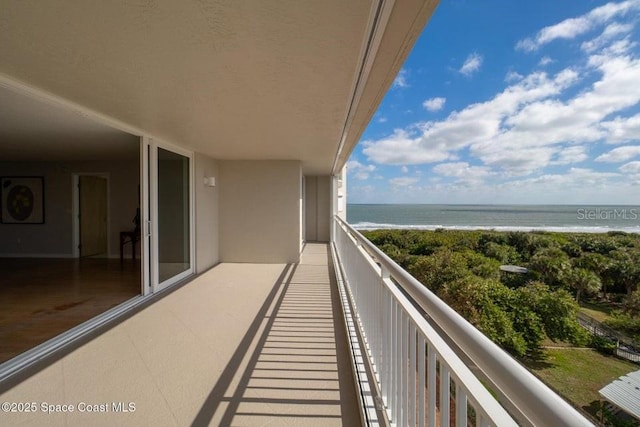 balcony featuring a water view and a beach view