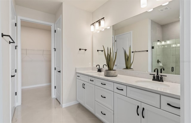 bathroom with tile patterned flooring, vanity, and walk in shower