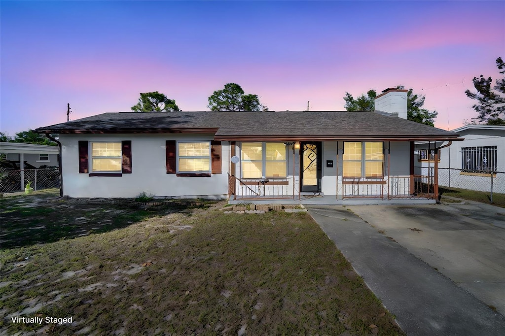 single story home featuring a yard and covered porch