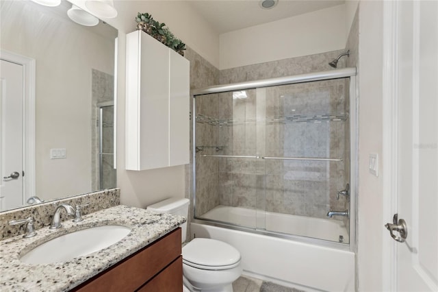 bathroom featuring enclosed tub / shower combo, vanity, and toilet