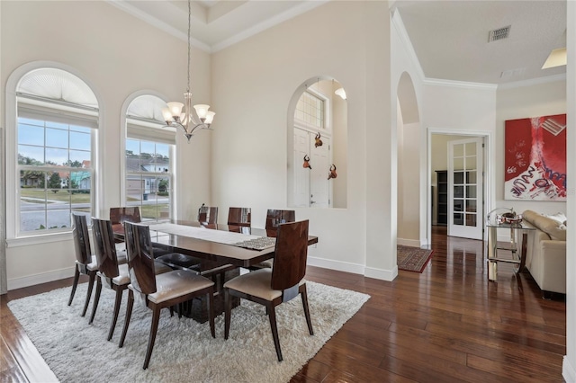 dining space featuring dark wood-style floors, ornamental molding, a notable chandelier, and baseboards