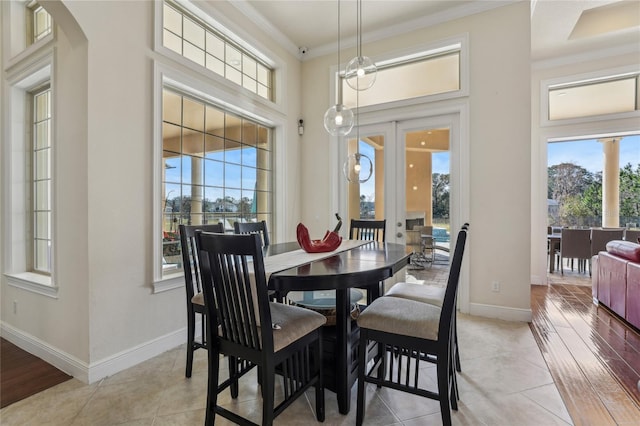 dining room featuring light tile patterned floors, french doors, ornamental molding, and baseboards