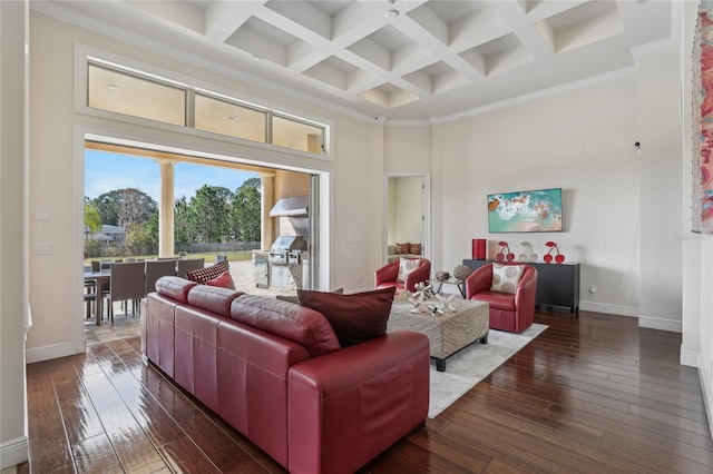 living area featuring dark wood-style floors, coffered ceiling, a towering ceiling, and baseboards