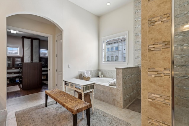 bathroom with a garden tub, a walk in shower, and tile patterned floors