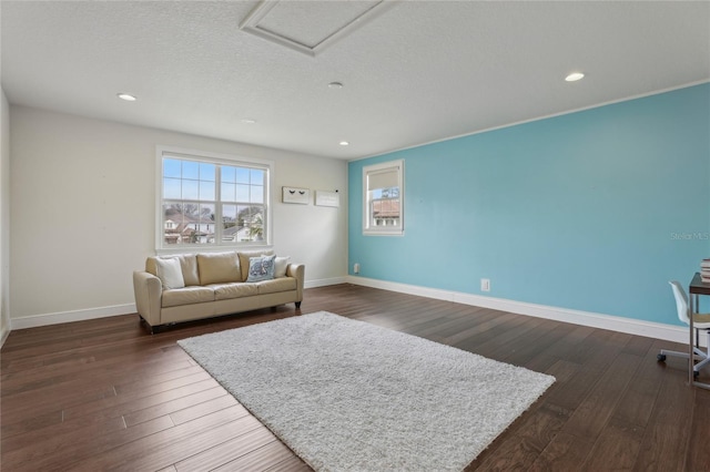 interior space with a textured ceiling, dark wood-type flooring, recessed lighting, and baseboards